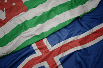 waving colorful flag of iceland and national flag of abkhazia.