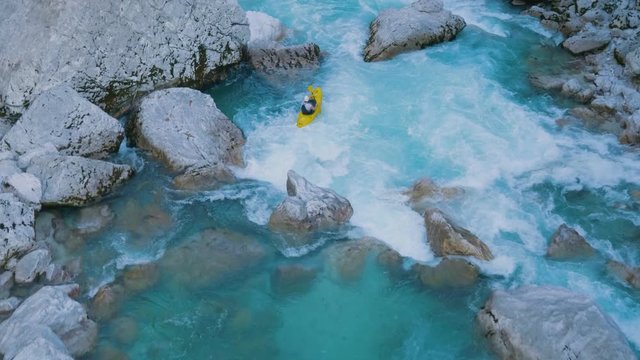 A guy kayaking through rapids