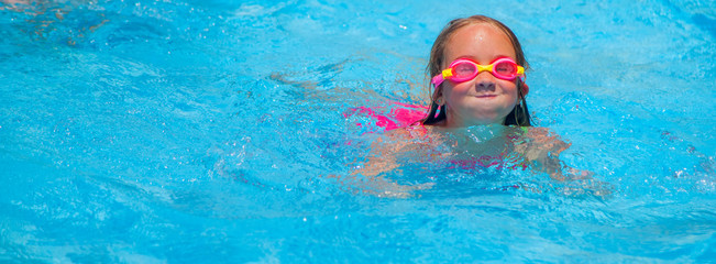 Happy cute little girl learn to swimming and  relaxing in the pool. Holidays in hot countries...