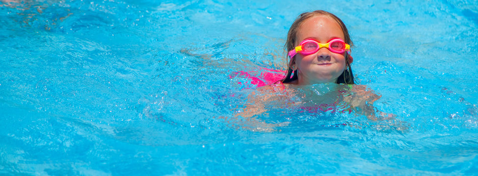 Happy cute little girl learn to swimming and  relaxing in the pool. Holidays in hot countries concept.