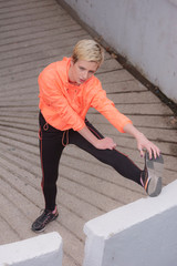 Young female runner prepairing for jogging in the city street. Fit body requires hard work. Urban sport concept. Young female exercising in sport clothes.