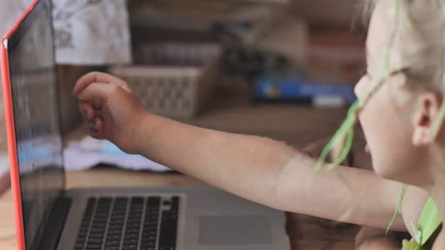 Children are browsing photos on a laptop.