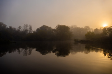 Obraz na płótnie Canvas sunrise over foggy lake