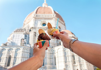 Frauenhände mit Eis Gelato auf dem Hintergrund der Stadt Sehenswürdigkeit Kathedrale Santa Maria del Fiore im historischen Zentrum von Florenz, Italien, Europa, einem berühmten Touristenort