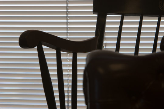 Sillo of office chair against closed window blinds