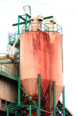 Storage tanks used for various food or petrochemical products. Refinery metal silos lined up in an industrial area.