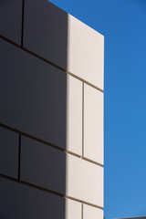 Sunlight on abstract patterned wall against clear blue sky