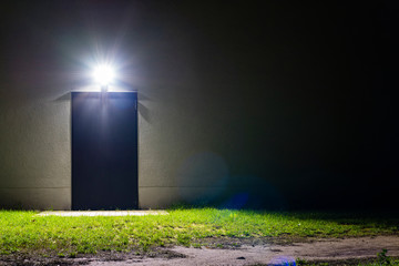 illuminated simple door by night, barren facade