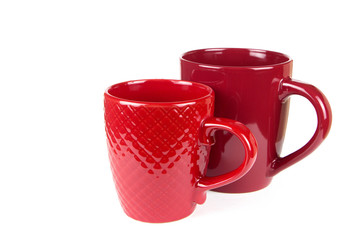Two ceramic red cups on a white background.