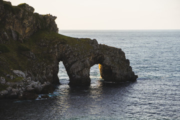 Beautiful scenic view at sunset of the north coast of Spain, by the island of San Juan de...
