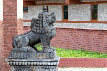 Fototapeta na wymiar Stone traditional guard lions near the temple in the ethnic centre, copy space