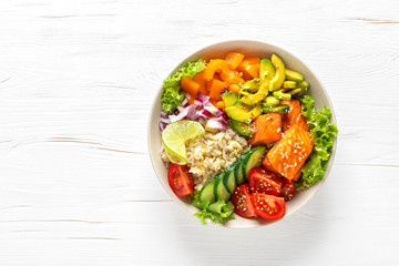 Buddha bowl with grilled salmon fish, fresh cucumber, tomato, onion, sweet pepper, avocado, lettuce salad and rice, healthy balanced eating