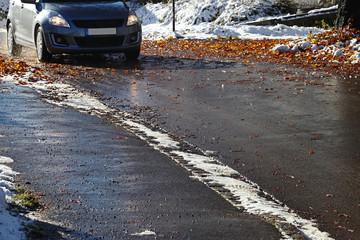 Unfallgefahr für Autos durch nasses Laub und Schnee auf der Straße