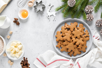 Christmas or X-mas baking culinary background, cooking recipe. Xmas, Noel gingerbread cookies on kitchen table and ingredients for festive baking. New Year holiday decorations with fir tree