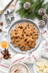 Christmas or X-mas baking culinary background, cooking recipe. Xmas, Noel gingerbread cookies on kitchen table and ingredients for festive baking. New Year holiday decorations with fir tree