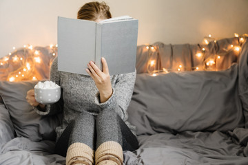 Woman reading book in cozy room.