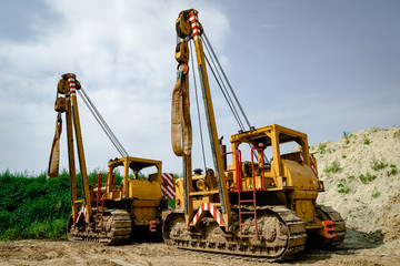 Gaspipeline - Baumaschinen mit Kranvorrichtung auf einer Baustelle für das verlegen von Stahlrohren