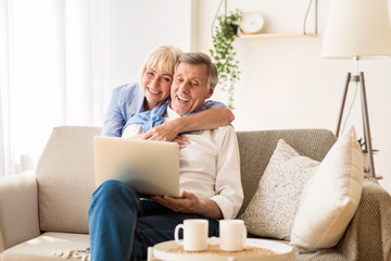 Happy senior couple having video call on laptop