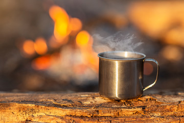 Travel cup on wood on fire background