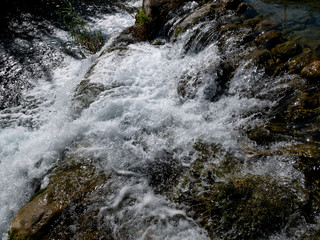 stream of water in the river with stones and foam
