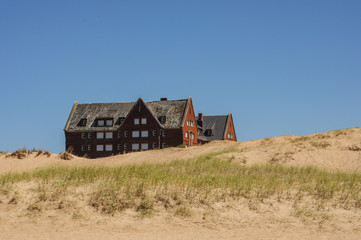 Fototapeta na wymiar Edificio en ruinas detrás de las dunas