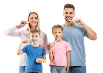 Portrait of family brushing teeth on white background