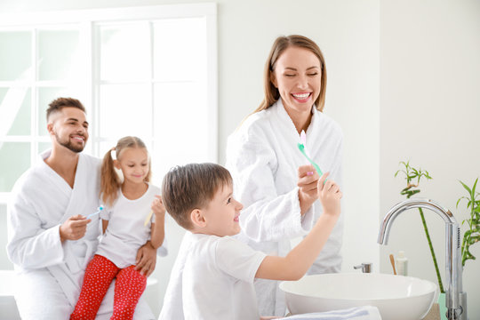 Family Brushing Teeth In Bathroom