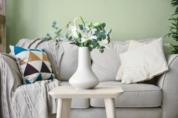 Fototapeta na wymiar Vase with flowers on table in modern room