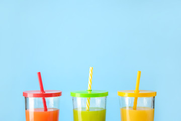 Glasses of fresh juice on color background