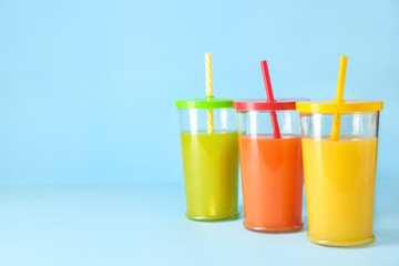 Glasses of fresh juice on color background