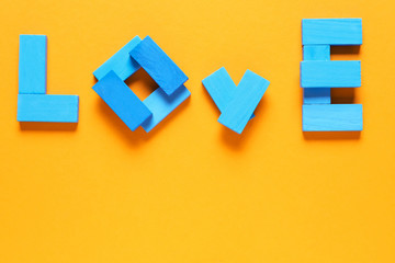 Word LOVE made of blocks on color background