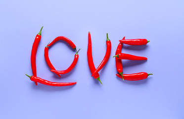 Word LOVE made of chili pepper on color background