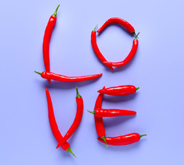 Word LOVE made of chili pepper on color background