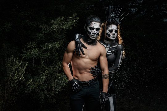 Pareja de j&oacute;venes pesados maquillados de calaveras en halloween