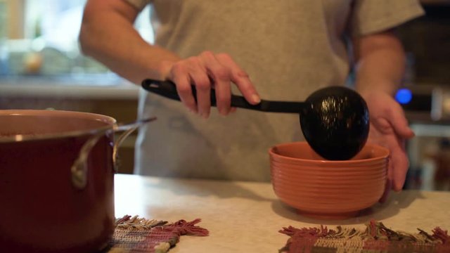 Scooping chili out of pot and moving into a bowl