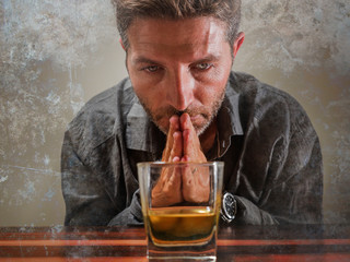 desperate alcoholic man . depressed addict isolated in front of whiskey glass trying not drinking...