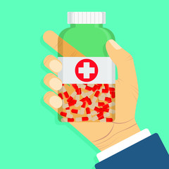 Doctor's hand holding a bottle of medical pills.
