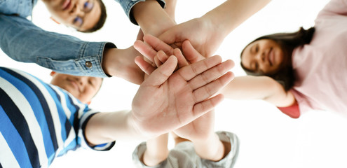 Concept of living together and Anti-Corruption. Closeup on the hands of Asian children overlapping, showing unity Mutual acceptance Education and learning in schools to develop intellectual skills