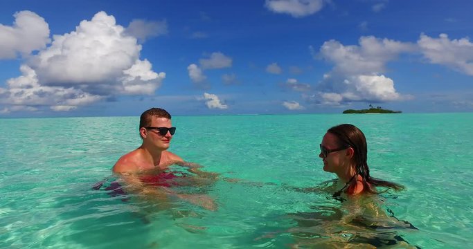 Couple swimming in the sea. Calm, relaxing. Peaceful, playing. Bora Bora. Honeymoon.