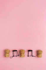 Minimal trendy concept with corks and muselets from champagne on pink colored background with copy...