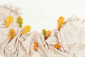 Obraz premium Bright yellow autumn leaves flat lay on white wooden background with copy space. Many leaves of oak tree and cozy warm palantine, autumnal theme. Top view.