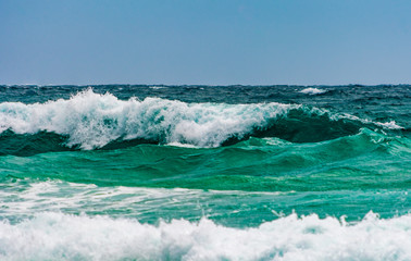 Turquoise colour ocean wave in windy day.