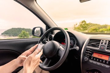 Driver using smartphone in car to find the route before driving.