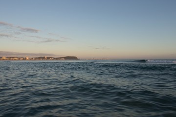 View From A Fishing Boat With Blue Water At Sunrise Towards Gold Coast City And Burleigh Headland With Orange Sky