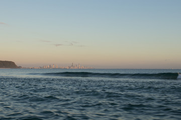 View From A Fishing Boat With Blue Water At Sunrise Towards Gold Coast City And Burleigh Headland With Orange Sky