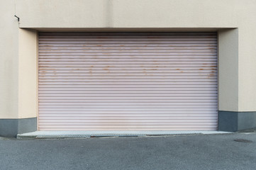 A closeup shot of automatic metal roller door used in factory, storage, garage, and industrial warehouse. The corrugated and foldable metal sheet offer space saving and provide urban and rustic feel