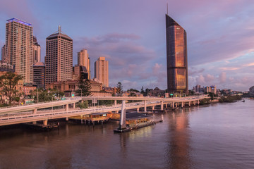 Brisbane City River At Sunset With A Dramatic Pink Pastel Sky With Buildings High Rises And Roads In The Distance
