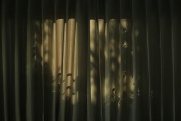 tree leaves shade cast light and shadow on brown curtain. afternoon in the house. sleepy atmosphere at home. sad depressed caged psychology and down concepts