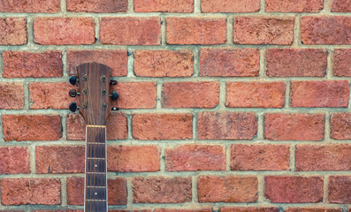 Guitar placed on a brick wall