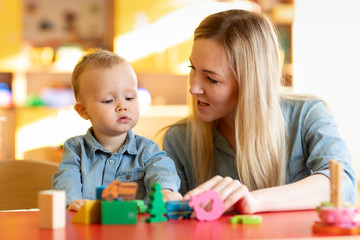 Mother and child son are talking and smiling while playing with educational toys at home